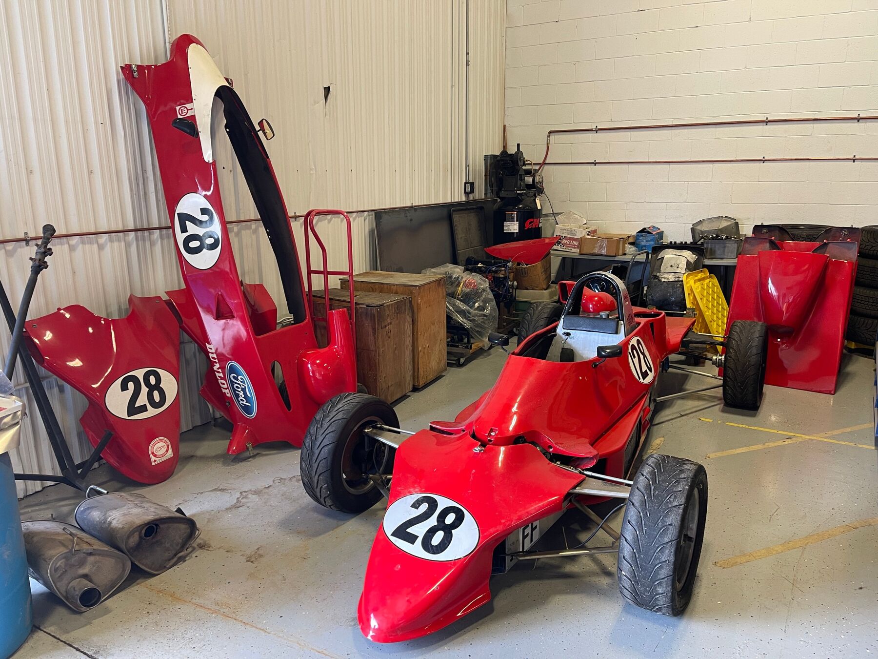 Reynard FF83 in red with #28 roundels, spare bodywork beside it